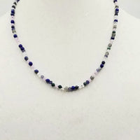 Field of Blue Bonnets. 14KYG, iolite, lapis, azuremalachite, moonstone, labradorite and jadeite necklace on purple silk.