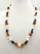 Baltic Solstice, a matinee length necklace of Baltic amber, lapis, and pearls with 14kyg on green silk