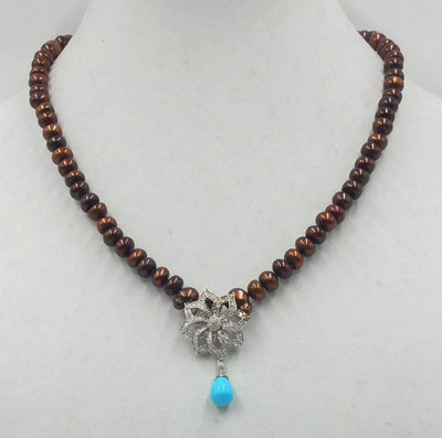 Get your sunglasses. This amazing necklace is blinding.  14KWG, bronze pearl necklace with 14KWG .72ct diamond & turquoise pendant on hand-knotted purple silk. 19.50