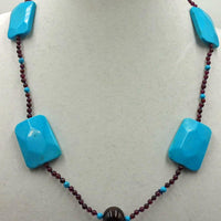 Magnesite, garnet, individually knotted with adjustable sterling necklace on blue silk.