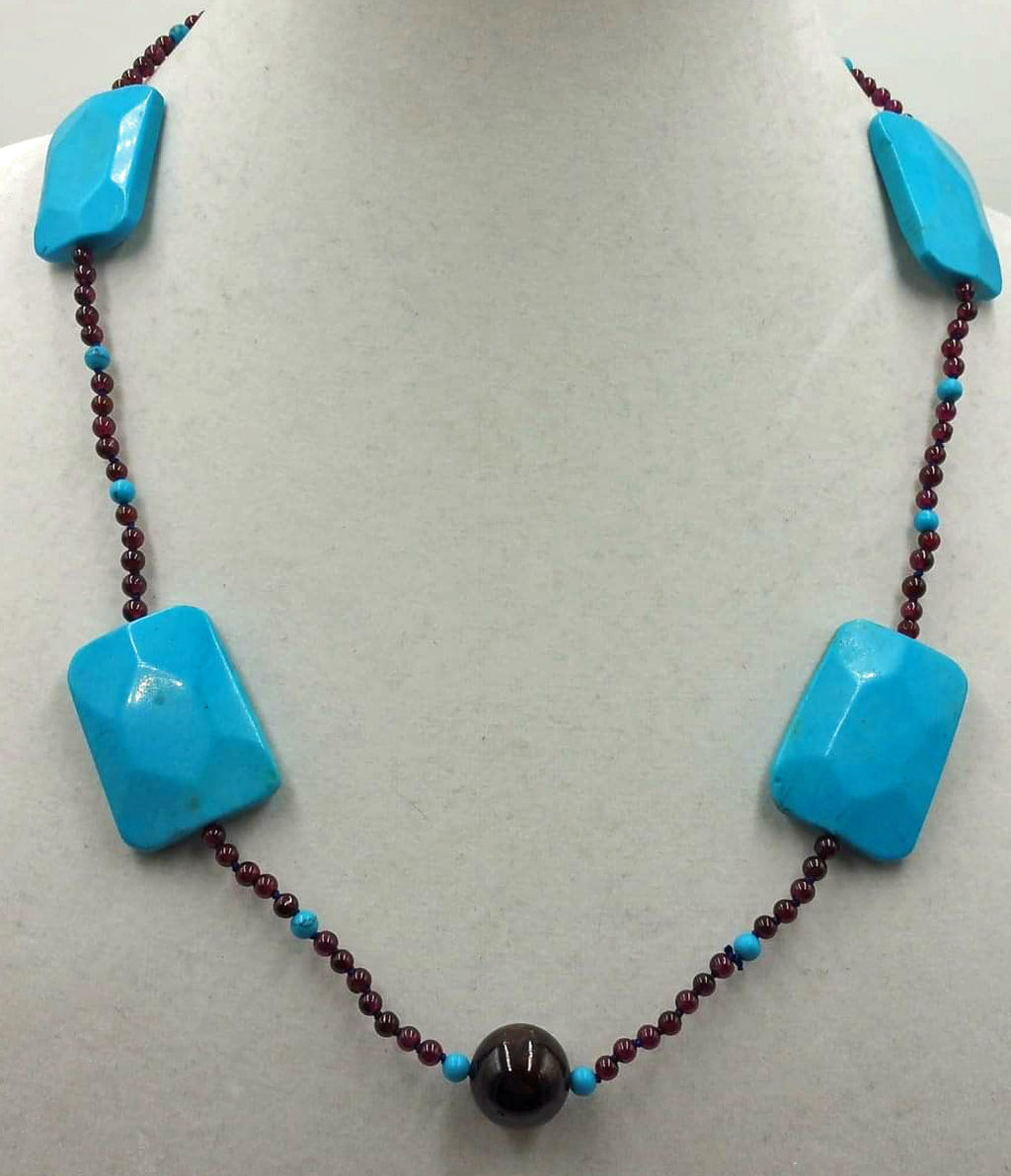 Magnesite, garnet, individually knotted with adjustable sterling necklace on blue silk.
