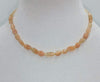 Butterscotch candy? No, it is a sunstone graduated necklace on yellow silk with 10K gold clasp. 16" length.