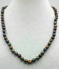 Bronze pearl necklace, matinee length on scarlet silk.