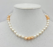 2-tone pearl choker with sterling silver clasp and accents on beige silk. 17in length.