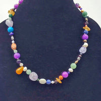 Multi-stone cosmic necklace with sterling silver clasp on white silk.