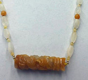 Precious yellow & orange jadeite, moonstone, & 14KYG necklace on bright yellow silk.