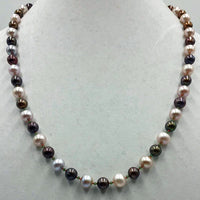 Bi-tone pearls, faceted jadeite, and 14KYG on crimson silk.