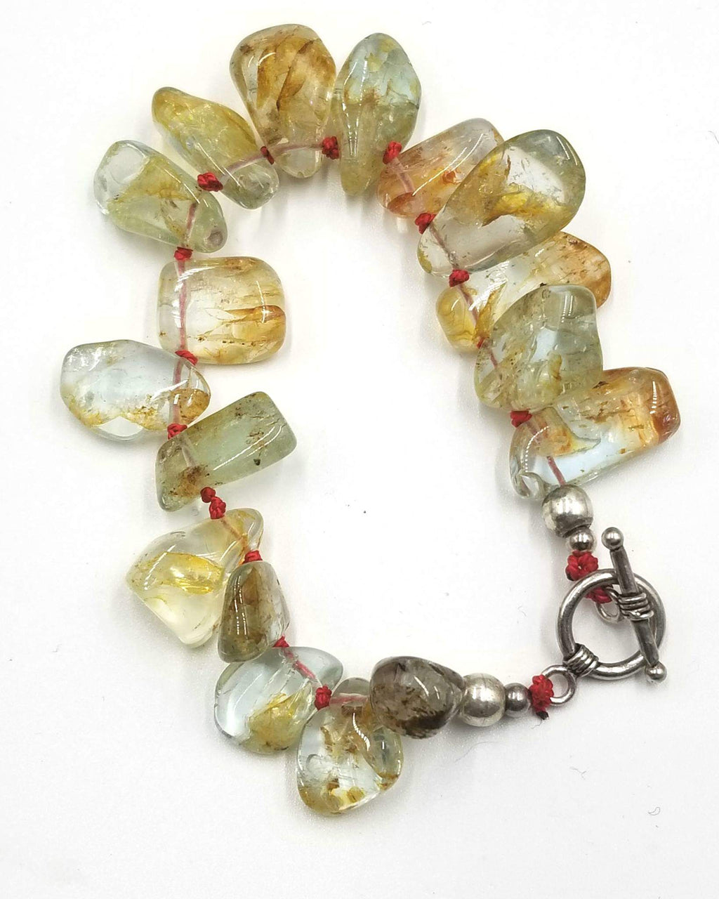 Rutilated Quartz, sterling silver toggle bracelet on scarlet silk.