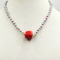 Silvery pearls on crimson silk, with coral and nephrite jade focal & sterling silver clasp. 18.25" Length.