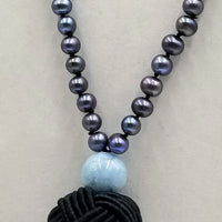 Exquisite Peacock pearl mala necklace on black silk with aquamarine guru bead.