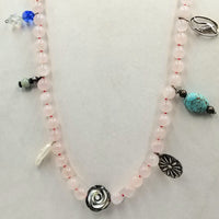 "St. Brigid's Feast"  Pearl-shaped rose quartz, with pendants of Sterling silver, Mother of pearl focal, dyed howlite, golden coral, & more hand-knotted on crimson silk.