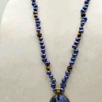 Indigo dyed freshwater cultured pearls & tiger's eye necklace with brass sodalite pendant with hand-knotted coppertone silk.