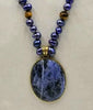 Indigo dyed freshwater cultured pearls & tiger's eye necklace with brass sodalite pendant with hand-knotted coppertone silk.
