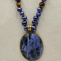 Indigo dyed freshwater cultured pearls & tiger's eye necklace with brass sodalite pendant with hand-knotted coppertone silk.